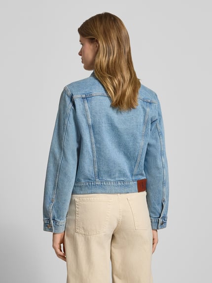 Frauenmodel trägt Regular Fit Jeansjacke mit Brusttaschen Modell 'Panama' von Calvin Klein Jeans aus elastischem Baumwoll-Mix, hellblauer Denim mit Logo-Patch und Umlegekragen, Rückenlänge 50 cm, Ganzkörperansicht Rückansicht.