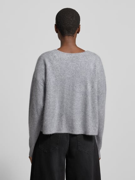 Frauenmodel trägt Strickjacke aus Wolle Kaschmir ohne Verschluss von BOSS in Grau, unifarben, Strukturmuster, Feinstrick, Ganzkörperansicht Rückansicht.