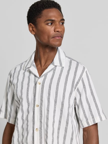 Männermodel trägt Regular Fit Freizeithemd aus reiner Baumwolle von Tom Tailor mit weißen und grauen Streifen, Nahaufnahme Oberkörper.