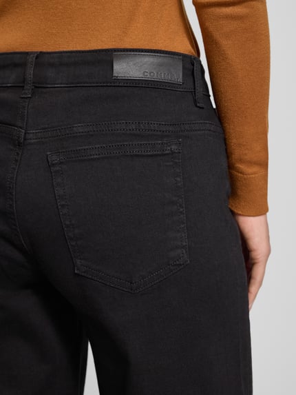 Frauenmodel trägt Relaxed Fit Jeans mit 5-Pocket-Design von comma, schwarze Baumwoll-Mix-Jeans mit Ziersteinbesatz, Detailaufnahme Rückansicht.