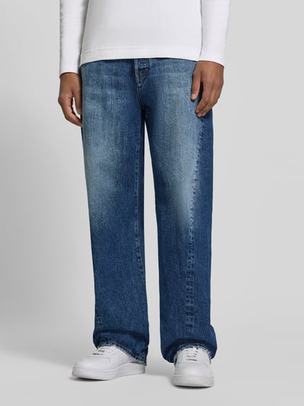 Männermodel trägt Loose Fit Jeans aus puur katoen van Dsquared2 in blauwe Used-look met 5-pocketmodel en knoop- en ritssluiting, detailopname vooraan.
