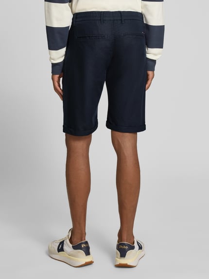 Męski model nosi szorty chinosy Chino-Shorts mit Tunnelzug Modell 'DAWSON' od Lerros, mieszanka bawełny i lnu, krój regular fit, tunel, kieszenie z tyłu, szerokość w rozmiarze 32: 42 cm, długość wewnętrzna nogawki w rozmiarze 32: 26 cm, granatowy, widok całej sylwetki od tyłu.