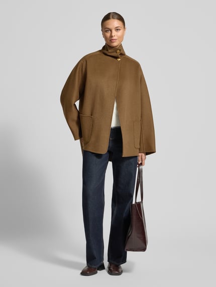 Vrouwenmodel draagt Oversized Mantel aus Woll-Mix van Tommy Hilfiger in effen bruin met opgestikte zijzakken en asymmetrische zoom, voorkant geheel in beeld, Ganzkörperansicht von vorne.
