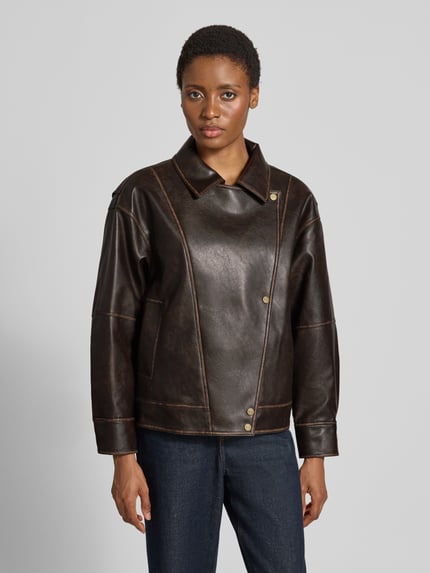 Frauenmodel trägt Regular Fit Jacke in Leder-Optik mit Umlegekragen von Liu Jo White, dunkle Farben, sichtbare Nähte, Knopfleiste, Logo-Detail, Ganzkörperansicht von vorne. Rückenlänge, Schulterbreite, Brustweite und Ärmellänge passend für Größe 36.