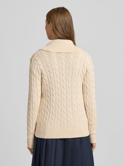 Frauenmodel trägt Cardigan mit Schnalle Modell 'TAYSIR' von Lauren Ralph Lauren aus reiner Baumwolle, Zopfmuster, Regular-Fit, Rückenlänge 56 cm, Ärmellänge 63 cm, cremefarben, strukturierte Stricktextur, Ganzkörperansicht Rückansicht.