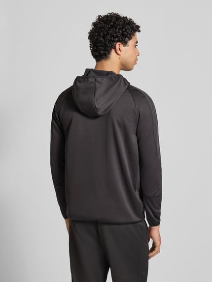Männermodel trägt Regular Fit Trainingsjacke mit Logo-Print von PUMA PERFORMANCE in Schwarz mit Kapuze und Reißverschluss, Ganzkörperansicht Rückansicht.