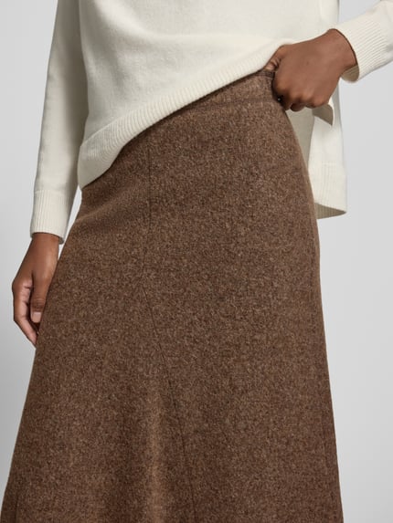 Vrouwenmodel draagt midirok uit mix van viscose en katoen van Christian Berg Woman, bruin, deelnaad, A-lijn, detailopname, Bandwijdte maat 36: 38 cm, totale lengte maat 36: 81 cm.