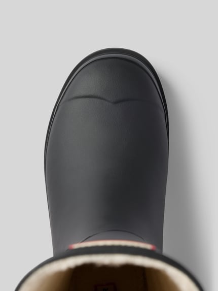 Produktfoto, Stiefel mit Label-Patch von Hunter in Schwarz, abgerundete Form, Innenfutter, profilierte Sohle, Detailaufnahme, Damen Stiefel.