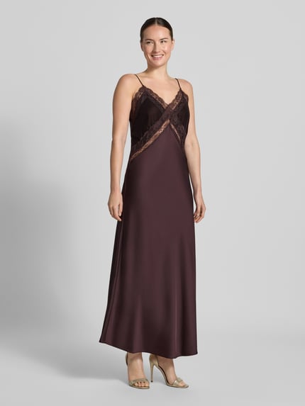 Frauenmodel trägt Slim Fit Kleid mit Viskose-Anteil von Stefanel, dunkelbraune Farbe, Spitzenbesatz, Spaghettiträger, Material-Mix, semitransparente Partien, Ganzkörperansicht von vorne.