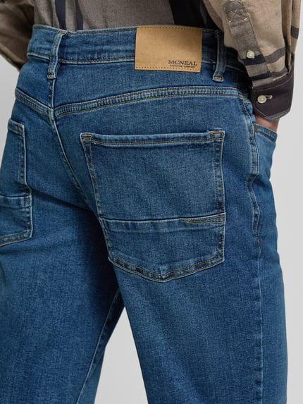 Mężczyznamodel nosi Regular Fit Jeans mit Eingrifftaschen von MCNEAL, mieszanka bawełny i elastanu, wpuszczane kieszenie, widok z tyłu, detal.