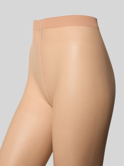 Frauenmodel trägt Hauttonanpassende Strumpfhose mit elastischem Bund von Falke, körpernahe Passform, transparent, Nahaufnahme Oberkörper.