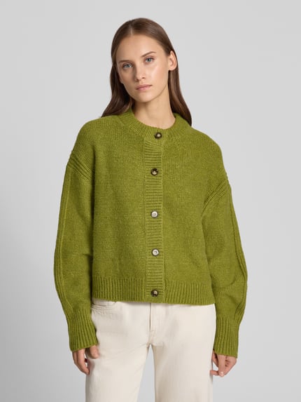 Frauenmodel trägt Boxy Fit Strickjacke Modell 'FLORA' von Topshop, grün, Rundhalsausschnitt, Knopfleiste, Strukturstrick, Ganzkörperansicht von vorne. Damen Strickjacke, Rückenlänge 54 cm, Ärmellänge 53 cm.
