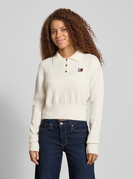 Vrouwenmodel draagt Cropped Strick-Poloshirt met Alpaka-Woll-Anteil Modell 'TJW FLUFFY POLO SWEATER' van Tommy Jeans in effen wit, regular fit, met lange mouwen, geribbelde boorden en label stitching, gebreid materiaal. Ganzkörperansicht van voren.