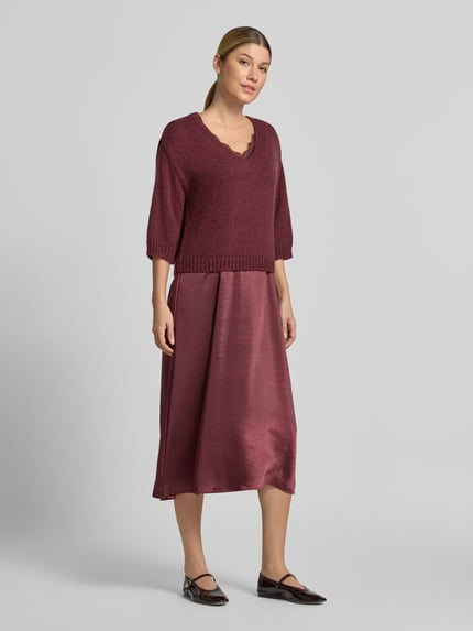 Frauenmodel trägt Figurumspielendes Freizeitkleid mit Spitzenbesatz von ROBE LÉGÈRE in Dunkelrot mit seidigem Glanz, Ganzkörperansicht von vorne.