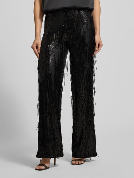 Kobieta modelka nosi czarne Stoffhose mit Paillettenbesatz od Milano Italy, luźny krój, elastyczny pas, zdjęcie z przodu, zbliżenie na nogi.