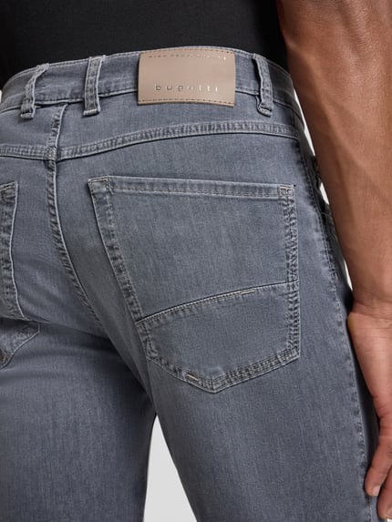 Männermodel trägt Regular Fit Jeans mit Eingrifftaschen von bugatti, grauer Baumwoll-Mix mit Stretch, Detailaufnahme Rückansicht.