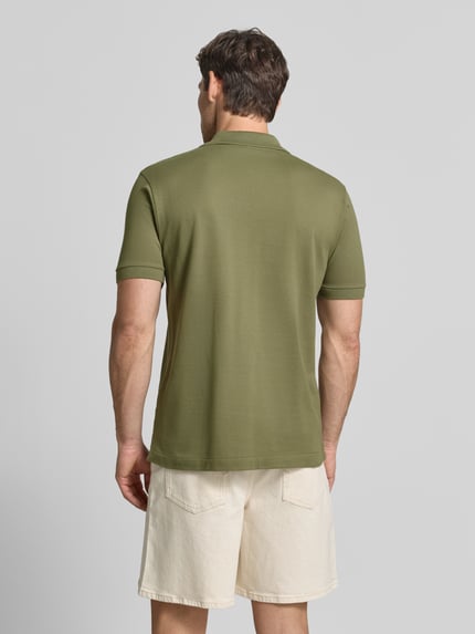 Männermodel trägt Regular fit poloshirt aus puur katoen van Lacoste in olijfgroen, gecombineerd met lichte shorts, Ganzkörperansicht Rückansicht. Heren poloshirt van Lacoste.
