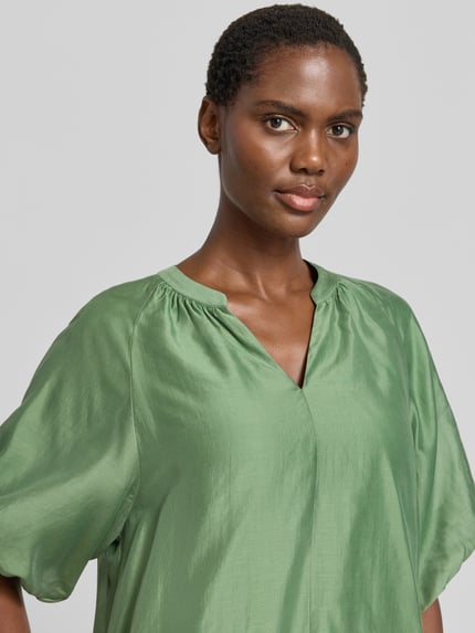 Frauenmodel trägt Loose Fit Blusenshirt aus Lyocell-Mix von s.Oliver BLACK LABEL in Optik: Unifarben mit Puffärmel, Nahaufnahme Oberkörper.