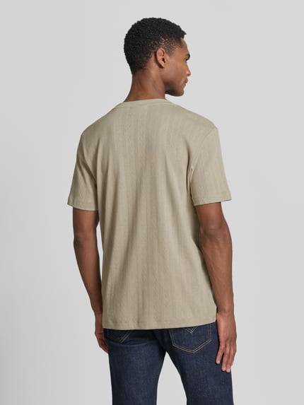 Männermodel trägt T-Shirt in Jaquard-Strick mit Rundhalsausschnitt von Lindbergh, Reine Baumwolle, Regular-Fit, Label-Detail, Rückenlänge 72 cm, Ganzkörperansicht Rückansicht.
