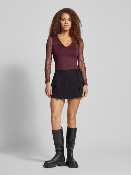 Frauenmodel trägt Slim Fit Body mit Spitzenärmeln Modell 'SIA' von Only, Optik: Unifarben, semitransparent, V-Ausschnitt, Langarm, Druckknopfverschluss, Materialverarbeitung: Stretch-Webstruktur mit feiner Spitze; Ganzkörperansicht von vorne.