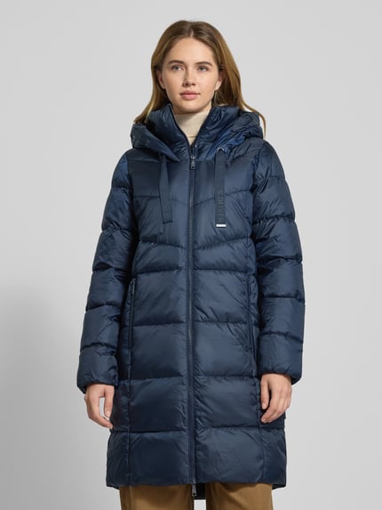 Frauenmodel trägt Regular Fit Steppmantel mit Kapuze von s.Oliver RED LABEL, Optik: Unifarben, mit Zweiwege-Reißverschluss, Label-Stitching, Reißverschlusstaschen, elastischem Ärmelabschluss, Ganzkörperansicht von vorne.