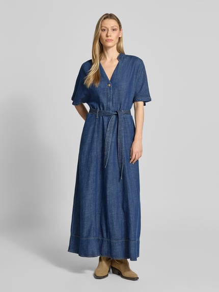 Frauenmodel trägt Midikleid aus Lyocell-Mix Modell 'Arge' von MOS MOSH in Blau mit abnehmbarem Stoffgürtel, Kurzärmelig, Ganzkörperansicht von vorne. Rückenlänge 140 cm, Brustweite 50 cm, Ärmellänge 35 cm, Taillierte Passform, Stehkragen mit V-Ausschnitt, Logo-Detail.