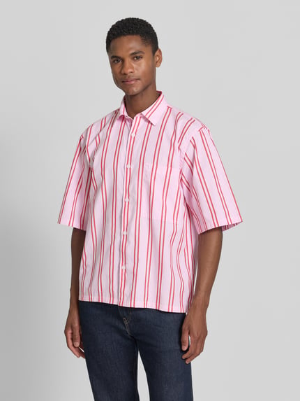 Männermodel trägt Regular Fit Freizeithemd mit Kentkragen und Brusttasche von Lindbergh, rosa mit roten Streifen, reine Baumwolle, Ganzkörperansicht von vorne.