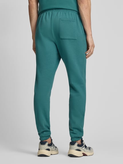 Männermodel trägt Sweatpants mit elastischem Bund von GAP in Türkis, Baumwoll-Mix, Regular-Fit, Gesäßtasche, Ganzkörperansicht Rückansicht. Innenbeinlänge bei Größe M: 74 cm.