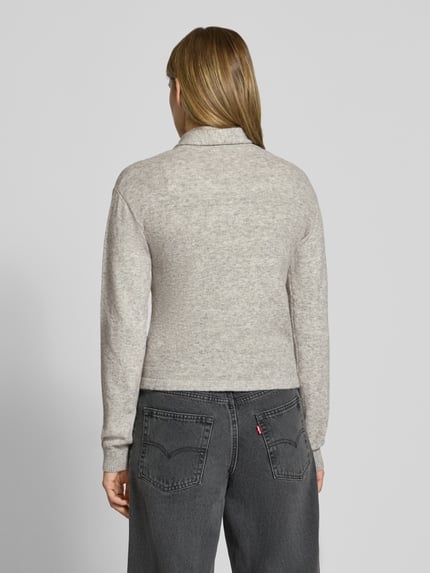 Vrouwenmodel draagt lichtgrijs gebreid jack van mix van wol en elastaan JJXX, regular fit, model 'JANE', ruglengte maat S 54 cm, mouwlengte maat S 61 cm, knoopsluiting, Ganzkörperansicht Rückansicht.