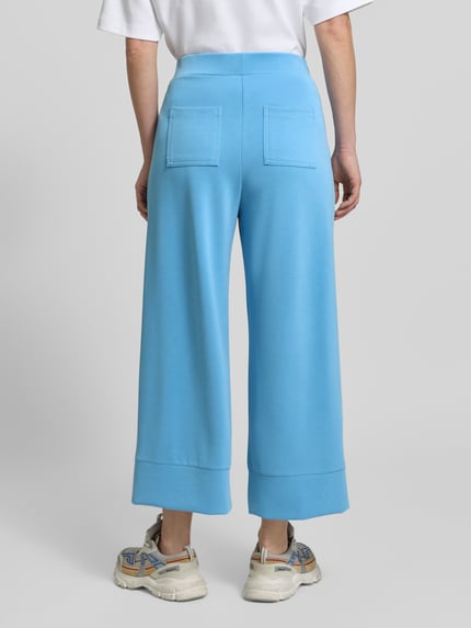 Frauenmodel trägt Wide Leg Sweatpants mit Eingrifftaschen von Rich & Royal in Hellblau, Modal-Mix mit Stretch-Anteil, elastischer Bund, Ganzkörperansicht Rückansicht.