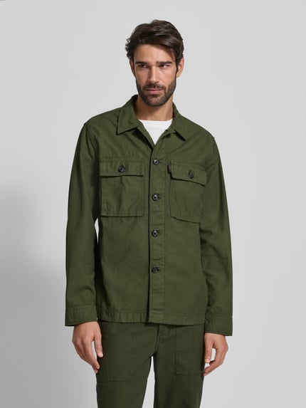 Mannelijk model draagt Regular Fit Hemdjacke aus reiner Baumwolle van Tommy Hilfiger in effen groen met borstzakken, nopstructuur, voorkant volledig zichtbaar, Ganzkörperansicht von vorne.