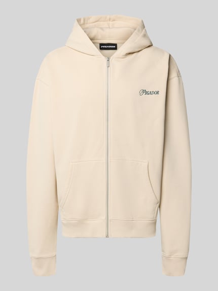 Produktfoto, cremefarbene Relaxed Fit Sweatjacke aus Baumwoll-Mix Modell 'Carloforte' von PEGADOR mit Kängurutasche, Logo-Stickerei, gerippten Abschlüssen.