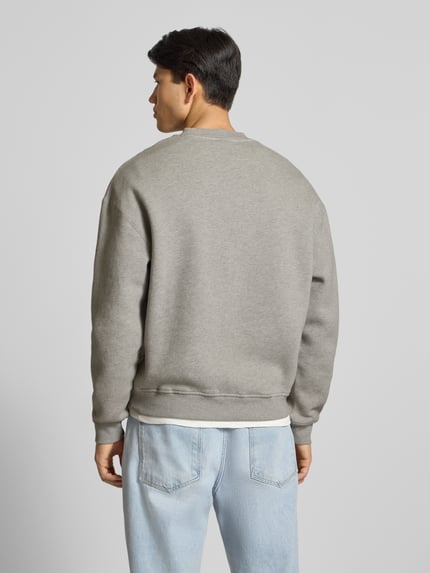 Männermodel trägt Sweatshirt mit Logo und Rundhalsausschnitt von BLKVIS aus reiner Baumwolle in Grau, Relaxed Fit, Ganzkörperansicht Rückansicht.