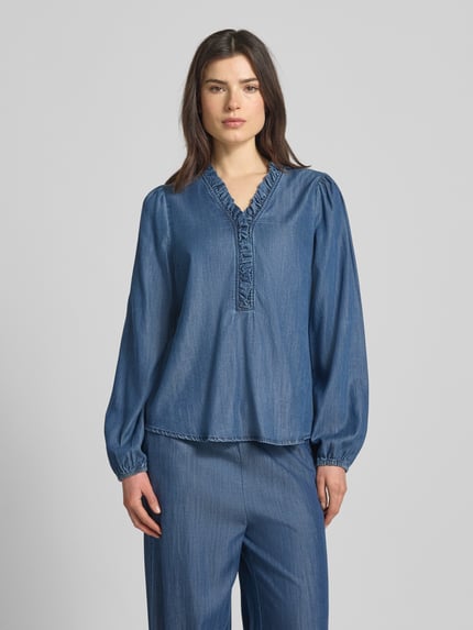 Modelka nosi Regular Fit Bluzkę w stylu denimowym model 'Wilke' od FREE/QUENT, Lyocell z wiskozą, niebieska, granatowe elementy, przód, krój regular fit, V-neck, falbany, długość tyłu 65 cm, długość rękawa 68 cm, ujęcie całej sylwetki z przodu.