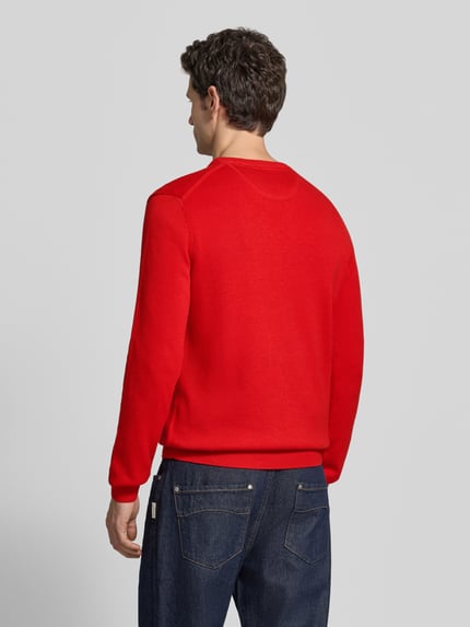 Männermodel trägt Regular Fit Strickpullover aus Baumwoll-Woll-Mix von Christian Berg Men in rood, rechte vormen, middelzware textuur, ganzkörperansicht rückansicht. Ruglengte maat M 70 cm, mouwlengte 68 cm, label-stitching, ronde hals.