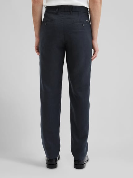 Männermodel trägt Tapered Leinenhose mit Gürtelschlaufen Modell 'OSBY JOGGER' von Marc O'Polo, kolor jednolity, krój tapered, materiał: len, zakładka w pasie, szlufki na pasek, wpuszczane kieszenie z przodu, kieszenie z tyłu, zapięcie na guzik i ukryty zamek błyskawiczny, Ganzkörperansicht Rückansicht.