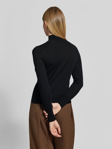 Frauenmodel trägt Rollkragenpullover aus Wolle mit Feinstrick von JAKE*S WOMAN COLLECTION, unifarbenes Design, Ganzkörperansicht Rückansicht.