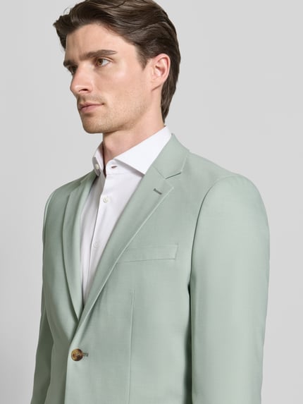 Männermodel trägt Slim Fit Anzugsakko mit Woll-Anteil Modell 'SLIM-NEIL' von SELECTED HOMME, Optik: Unifarben, Nahaufnahme Oberkörper.