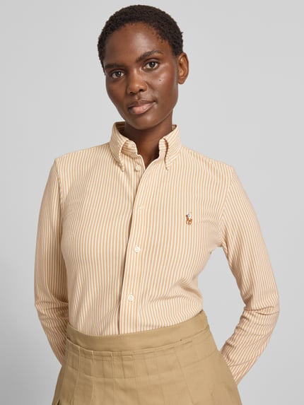 Frauenmodel trägt Regular Fit Hemdbluse aus reiner Baumwolle von Polo Ralph Lauren mit beigen und weißen Streifen, Nahaufnahme Oberkörper. Damen Hemdbluse von Polo Ralph Lauren.