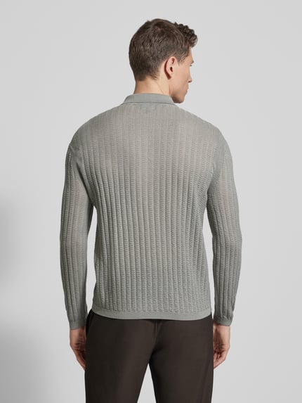 Männermodel trägt Slim Fit Pullover aus Lyocell-Mix mit Schurwoll-Anteil von Emporio Armani in Hellgrau mit Strick-Optik, Ganzkörperansicht Rückansicht.