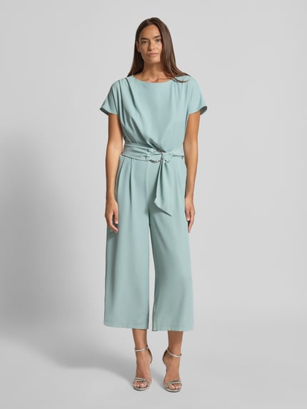 Frauenmodel trägt Jumpsuit mit Stretch-Anteil von Betty Barclay in Hellblau, Kurzarm, 7/8-Länge, mit Gürtel, Ganzkörperansicht von vorne.
