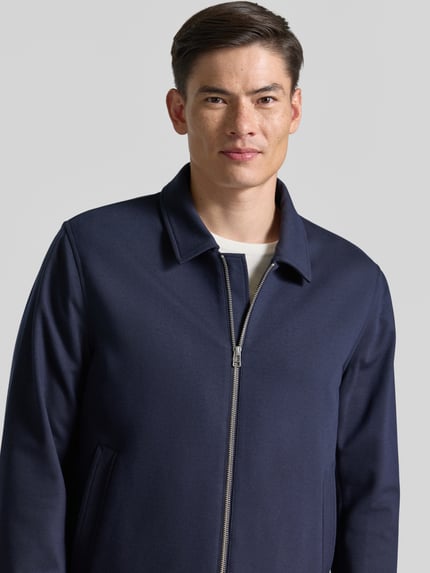 Männermodel trägt Blouson mit Zweiwege-Ritsluiting model 'BARNABY' van Tiger Of Sweden, viscose-mix, straight fit, navy, Nahaufnahme Oberkörper.