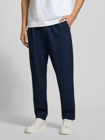 Männermodel trägt Stoffhose mit elastischem Bund von CK Calvin Klein, Baumwoll-Elasthan-Mix, Lockerer-Schnitt, Ganzkörperansicht von vorne.