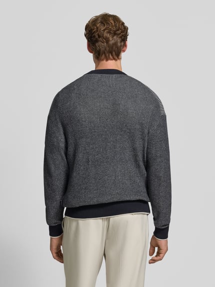 Männermodel trägt Regular Fit Strickpullover aus reiner Baumwolle von HECHTER PARIS in Dunkelgrau mit feiner Struktur, Ganzkörperansicht Rückansicht. Rückenlänge 63 cm, Ärmellänge 61 cm, elastische Abschlüsse, Rundhalsausschnitt.