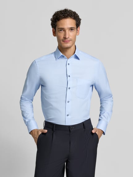 Männermodel trägt Modern Fit Businesshemd aus reiner Baumwolle von OLYMP in Hellblau, glatte Textur, Ganzkörperansicht von vorne, Herren Businesshemd von OLYMP.