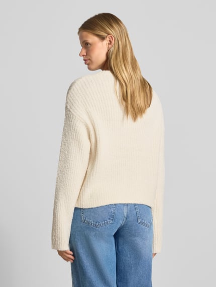 Frauenmodel trägt Relaxed Fit Strickpullover mit elastischen Abschlüssen von REVIEW in Creme, lockere Passform, Rückenansicht, Nahaufnahme Oberkörper.
