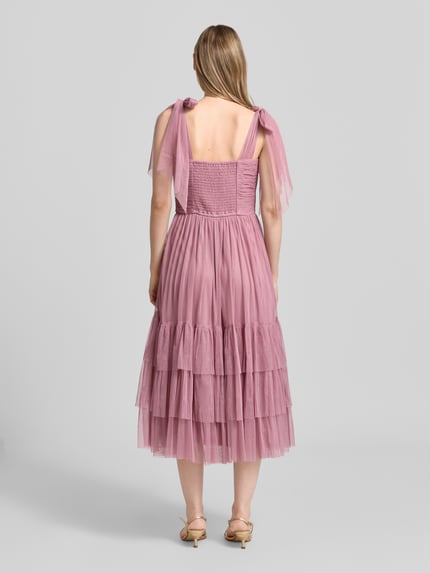 Frauenmodel trägt Knielanges Cocktailkleid im Stufen-Look von LACE & BEADS aus Mesh in A-Linie mit Drapierungen, Rückenlänge 104 cm, Ganzkörperansicht Rückansicht.