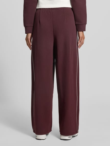 Modelka nosi Regular Fit Sweathose aus Baumwoll-Mix von Lacoste Sport w kolorze bordowym z kontrastowymi przeszyciami, pełny widok od tyłu.