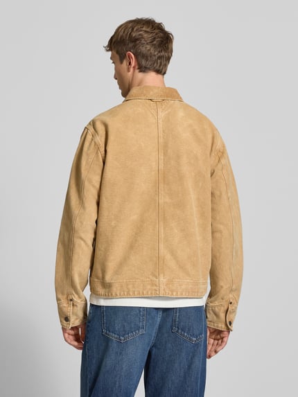 Männermodel trägt Regular Fit Jeansjacke aus reine Baumwolle mit Cordkragen von Tommy Jeans, hellbraune Farbe, lockere Passform, Ganzkörperansicht Rückansicht. Herren Bomberjacke / Blouson von Tommy Jeans.