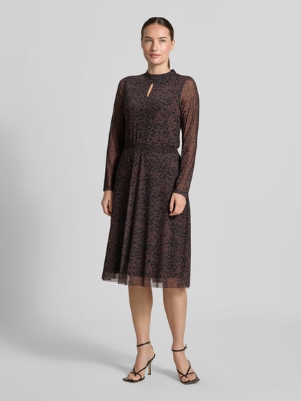 Frauenmodel trägt Knielanges Kleid mit Stretch-Anteil von MORE in dunklem Animal-Print, elastischer Tailleneinsatz, Stehkragen, langärmlig, leicht taillierte Passform, blickdichter Unterrock, semitransparente Ärmel, Ganzkörperansicht von vorne.